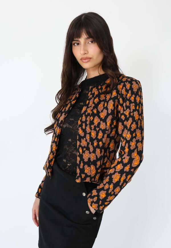 Chaqueta Gabriela Peplum negro florecitas mostaza Natalia Seguel, perspectiva de espalda y caída